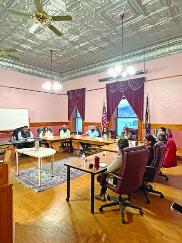 The candidates seated at the horseshoe table to answer questions. Photo credit DeAnne Gallegos