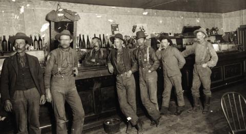 An unidentified saloon in the 1890s, with a long bar and relatively low ceiling, probably in the early 1890s. A poster on the wall mentions the Silverton Railroad. The saloon could have been in Silverton or Red Mountain Town. Photo courtesy of San Juan County Historical Society
