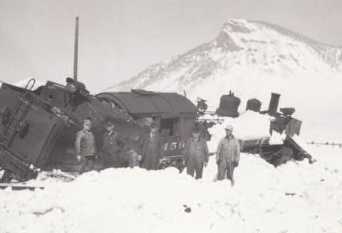 Engine 459 leans badly in deep snow with five men standing in the snow. This train derailed on the wye below Silverton on March 15, 1941. Photo: Courtesy of the Silverton Standard &amp; the Miner files.