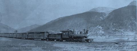 A Silverton Northern Railroad train hauls 10 carloads of zinc concentrates into Silverton, around 1925, pulled by SN #4, with two men on the third boxcar. San Juan County Historical Society photo