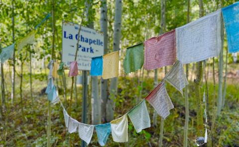 Prayer Flags hang at the sign to La Chapelle Park. Photo by DeAnne Gallegos