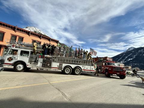 The two fire trucks full of school kids parked in the middle of the street during parade photo by DeAnne Gallegos