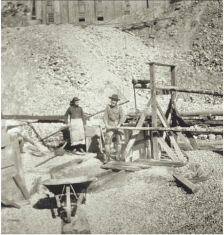 Courtesy of San Juan County Historical Society Two men, with a wheelbarrow working a small headframe device. Date and location unknown.