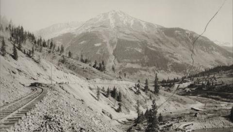 The Silverton Railroad in an undated photo taken just outside of Silverton. Workmen can be seen working on the track in the distance. At right, a dammed-up Cement Creek forms a pond from which a flume flows to an ice plant. San Juan County Historical Society photo