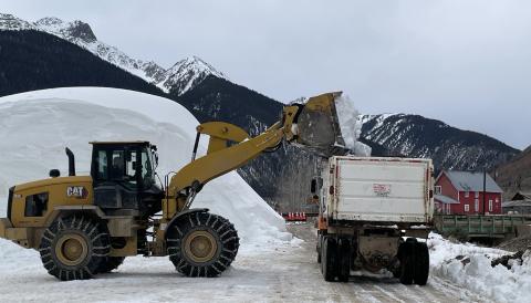 Dump trucks being filled with the man-made snow which is necessary to fill in the skijoring course Photo by Jan Zabinski