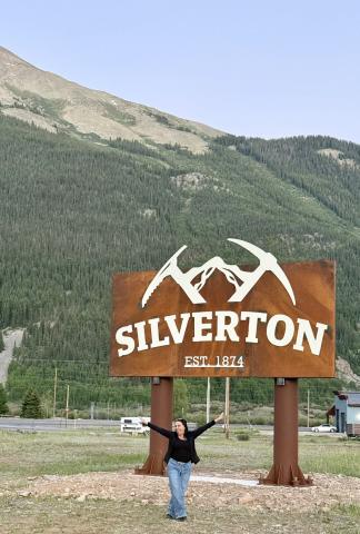 Angelia Noble taking a selfie with the new Town sign, just like the tourists do photo by DeAnne Gallegos