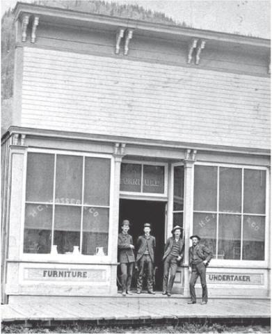 Photo courtesy of San Juan County Historical Society The Prosser Building at 1121 Greene Street was opened for business in June 1183, with Horace Greeley Prosser operating a furniture store and undertaker service. The building is now home to San Juan Sweets, next door to the Brown Bear Cafe. In the background can be seen the old wood-frame Silverton School which was building in 1884.