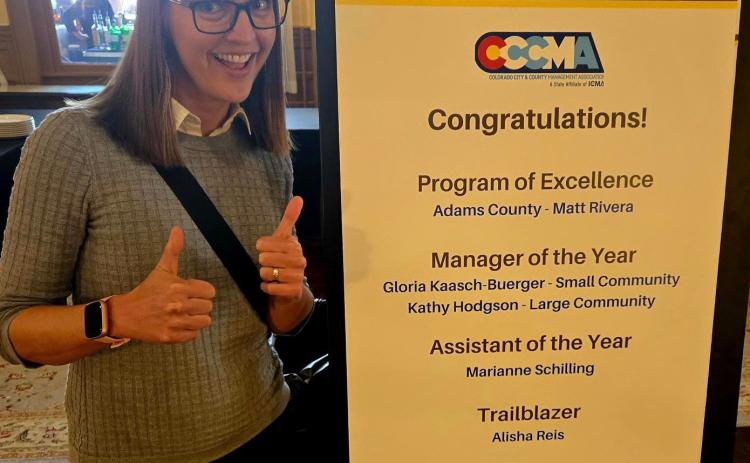 Town Administrator Gloria Kaasch-Buerger poses in front of the CCCMA conference sign that celebrated her big win in Glenwood. Photo credit Gloria Kaasch-Buerger