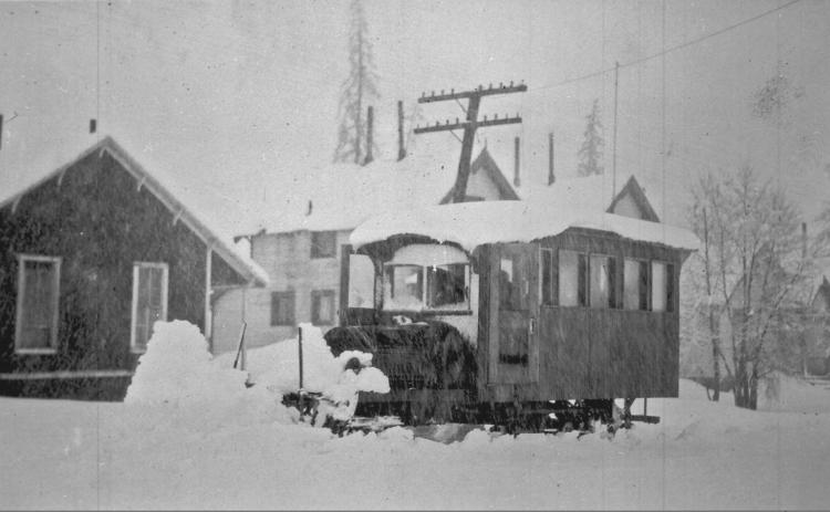 One of the George Boss stages in 1200 block of Greene Street, circa 1910. The photo shows an open buggy with at least 10 persons on it, pulled by four-horse team, facing northeast on Greene Street. The man on white horse at rear of stage is talking with someone on stage. San Juan County Historical Society photo