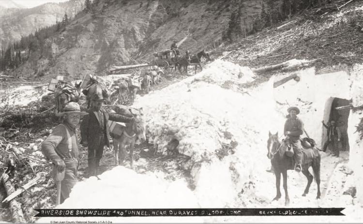 The Riverside Slide on Red Mountain Pass, with a snow tunnel on the right, and horses on top pulling a wagon, along with a pack string of burros to the left in an undated photo.