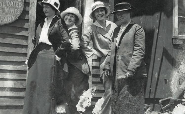 A cheeky brood of women pose outside the office of the Gold King Consolidated Mining Co. at Gladstone in 1912. Donning a hat [or a hardhat] is Cora Pitcher. Patty Slattery smiles brightly, while Maud Hartley bobs a curtsey behind Ellen Brown. San Juan Historical Society