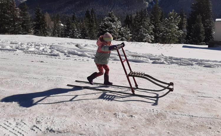 Photo credit Larry Raab Four year old Claudia kick sledding on Snowden Street.