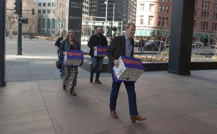 Michael Bennet &amp; his wife Susan walking in petitions with his team
