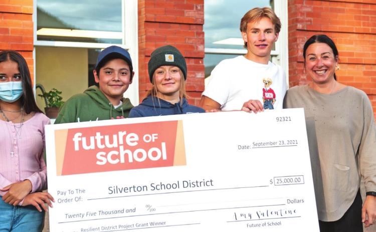 Silverton High School students accepted the award alongside school leadership. Left to right Karely Ortega, Alejandro Torres, Kharis Weller, Paton Edwards, and Amy Valentine (from Future of Schools) hold the giant check. Photo Credit David Emory.