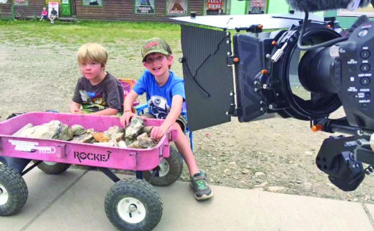 Behind the scenes shot of kids selling rocks by the train. Photo credit David Dibble