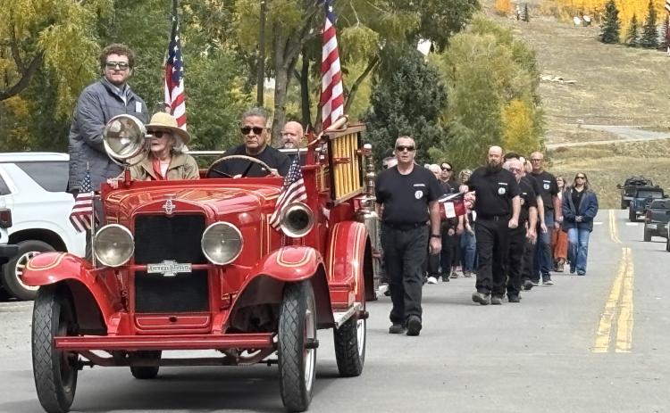 Fire Chief Gilbert Archuleta leads the funeral procession with Ron’s widow Barbara Renowden. photo by Barbara McLachlan
