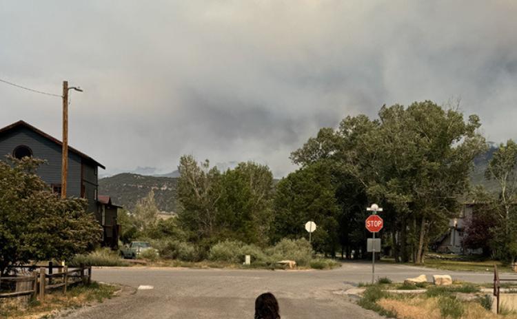 Ava Andrade on a street in Ridgway with a smoke filled horizon Photo by Katey Fetch
