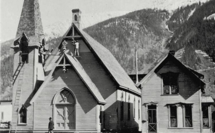 Two men work on the First Congregational Church as a pedestrian strolls by, probably around 1930. Photo courtesy of San Juan County Historical Society