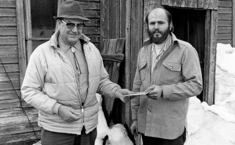 Ceremonial transfer of title to site of former Silverton Northern Ticket Office and Depot in Silverton from the Denver &amp; Rio Grande Western Railroad to the San Juan County Historical Society Roadmaster. Jack Rentfrow (left) hands documents to Society chairman, Alfred Klinke (right). Photo was taken on the Northeast side of the Silverton Northern Ticket Office and Depot on 10th Street. April 1976 Photographer: Larry J. Duthie Photo courtesy of the San Juan Historical Society
