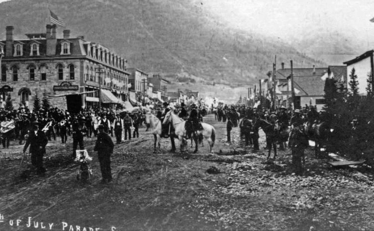 The 1891 Fourth of July float of Joseph Bordeleau, promoting his hardware store. View of the float and several individuals, taken directly in front of and facing the Bordeleau store front at 1139-1145 Greene. The float is a decorated wagon drawn by a 2-horse team and covered with signs and samples of the owner’s wares. Courtesy of San Juan County Historical Society