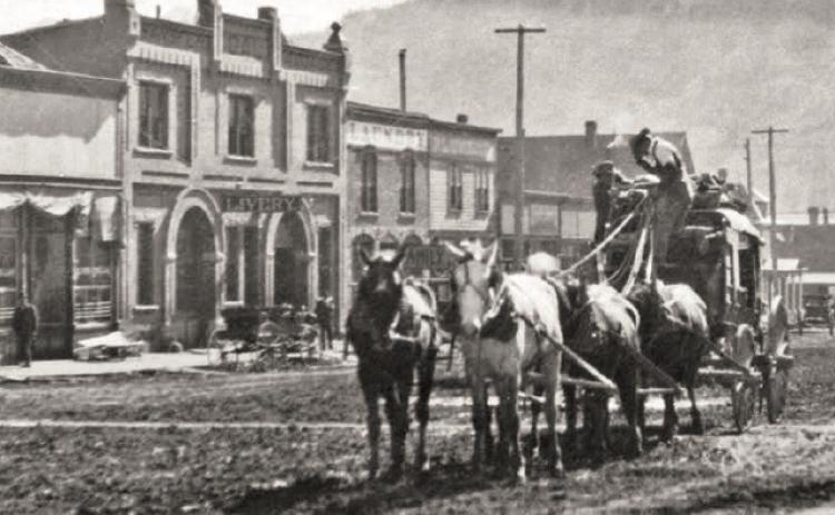 A stagecoach approaches the Hotel Imperial from lower Greene Street. This would have been a coach making regular trips between Silverton and Ouray. The view shows a street ditch and wooden sidewalks in front of the hotel, a hanging streetlamp, and business buildings in the 1100 block of Greene Street, east side, in the background. Photo courtesy of the San Juan County Historical Society