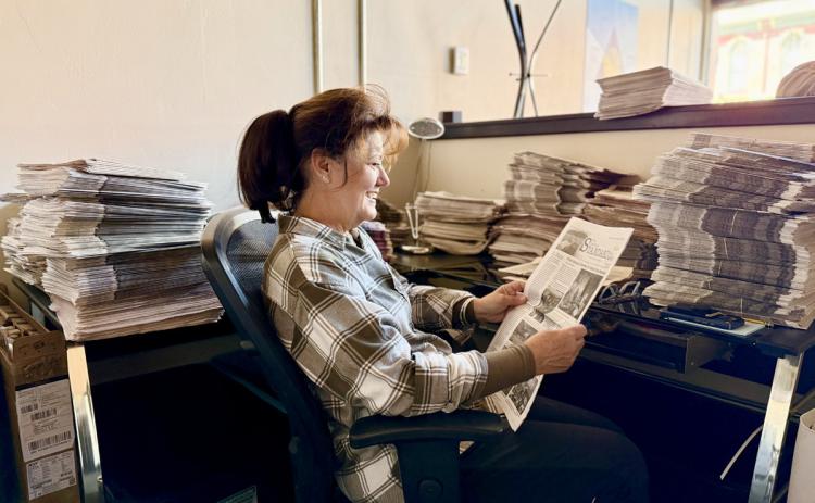 H.H. Smith's great granddaughter Susan Haupert sits in the current Silverton Standard's office and catches up on some recent newspapers photo by DeAnne Gallegos