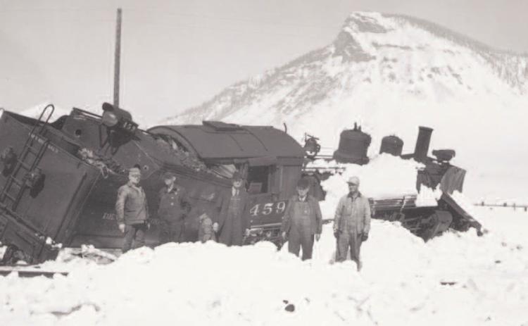 Engine 459 leans badly in deep snow with five men standing in the snow. This train derailed on the wye below Silverton on March 15, 1941. Photo: Courtesy of the Silverton Standard &amp; the Miner files.