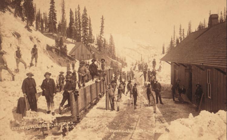 Track shovelers, likely returning from work, at the Red Mountain Town depot. The west face of the depot is at the right, with the main track by the platform and four cars on the western track. Image courtesy of: Judy Stine archives