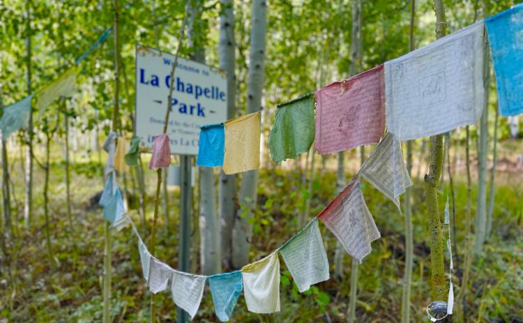 Prayer Flags hang at the sign to La Chapelle Park. Photo by DeAnne Gallegos