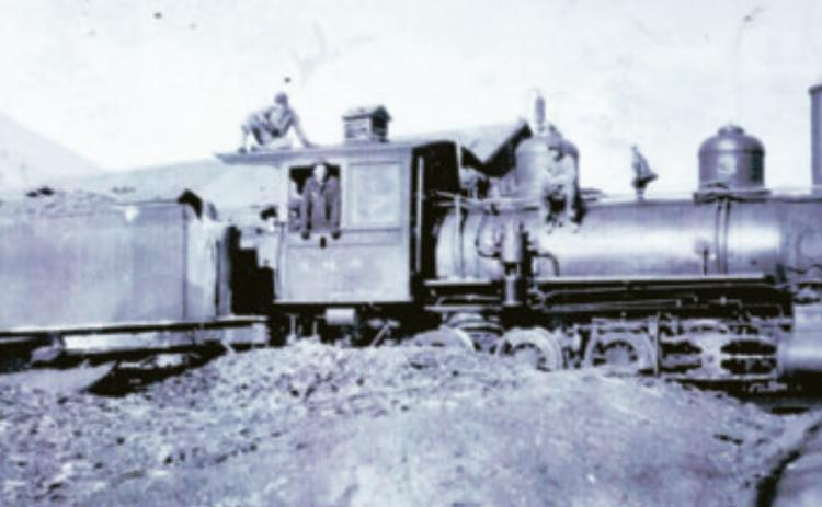 The Silverton Northern Railroad locomotive No. 3 in 1918, with the tender standing on the siding south of the Silverton Northern machine shop, facing the northeast. In the cab is William Pollman (1899-1970). John Pollman is on top of the cab. He would have been 13 in 1918. An unidentified boy is in the cab and an unidentified man is on the boiler. Photo courtesy of San Juan County Historical Society