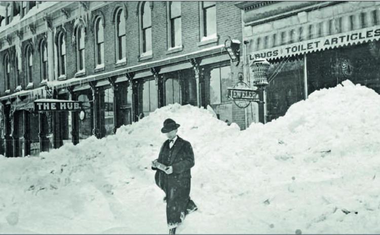 Good day, Sir. A nicely dressed, but unknown man walks through an apparent cut in the snowbank on Greene Street in front of the Grand Hotel, left, and Cunningham &amp; Crocker Drugstore, right. The sign for the Hub Saloon can be seen. What debauchery happened there? The photo comes from the archives and is believed to have been taken in 1906. Photo: Archival photo from the San Juan County Historical Society