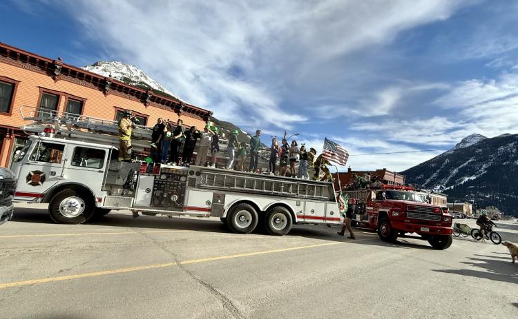 The two fire trucks full of school kids parked in the middle of the street during parade photo by DeAnne Gallegos
