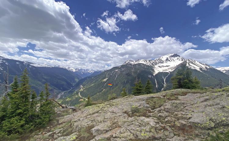 A pride flag on a summit above town. Photo by Blair Tice