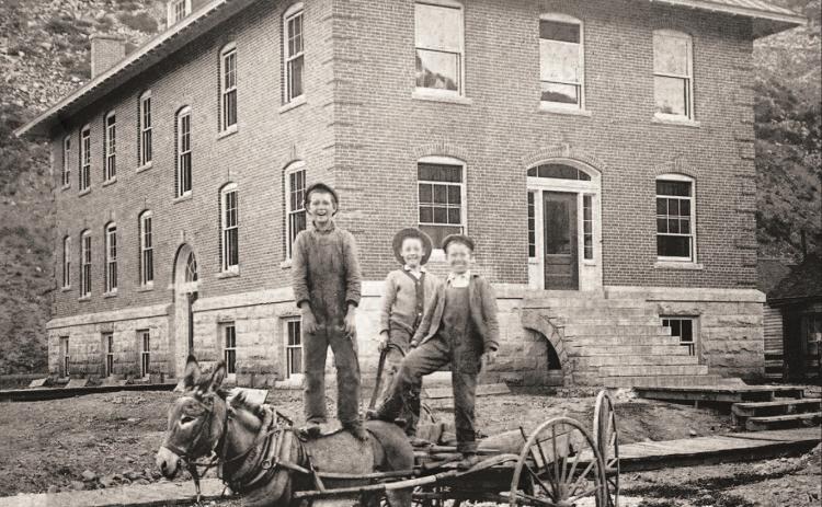 Three boys stand on a light wagon pulled by a burro in front of the Miners Union Hospital, 1315 Snowden Street, probably in 1912. From left are Myron Henry, Bill Gearry and Arthur Dreyer. The hospital building was only five years old at the time. Later this year its exterior will be restored in a $370,000 project funded by the State Historic Fund and the Department of Local Affairs. Photo courtesy of San Juan County Historical Society