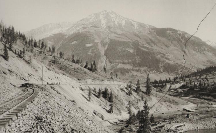 The Silverton Railroad in an undated photo taken just outside of Silverton. Workmen can be seen working on the track in the distance. At right, a dammed-up Cement Creek forms a pond from which a flume flows to an ice plant. San Juan County Historical Society photo