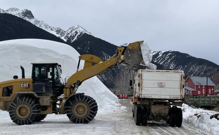 Dump trucks being filled with the man-made snow which is necessary to fill in the skijoring course Photo by Jan Zabinski