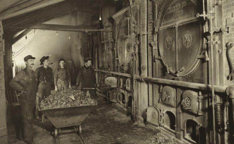 The main boiler room at the Gold King Mine in 1906. The photo shows three men around a coal car, and a fourth man shoveling coal into the firebox. The boiler tanks bear ornate endings, with the wording “the Gold King Consolidated Mines Co., 1900/Star Boiler Works.” Photo courtesy of San Juan County Historical Society
