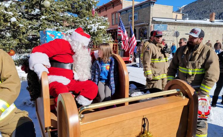 Anyela Carmack looking Santa right in the eye and asking for a puppy. Photo credit Gina Rosato