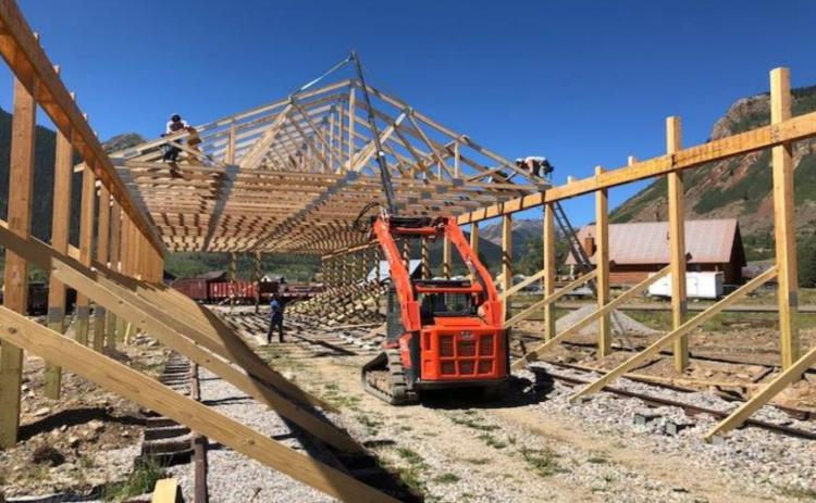 Crew from National Barn Company of Colorado Springs works on erection of the 40.5 by 224 foot Railcar Shed which will not only protect completed restorations but provide space for restoration work on additional cars in the future. Elevated platforms will provide both visitors and workers easier access to the cars.