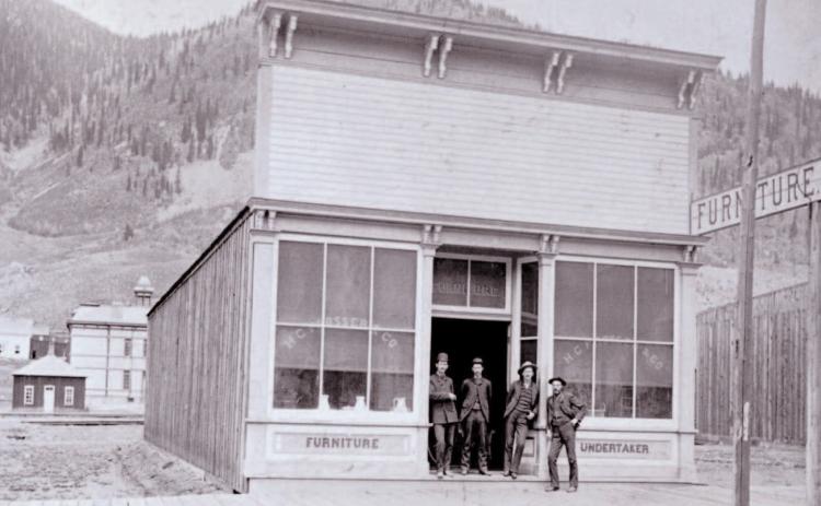 The Prosser Building at 1121 Greene Street was opened for business in June 1883, with Horace Greeley Prosser operating a furniture store and undertaker service. The building is next door to the Brown Bear Cafe. In the background can be seen the old wood-frame Silverton School which was built in 1884. Photo Courtesy of the San Juan Historical Society